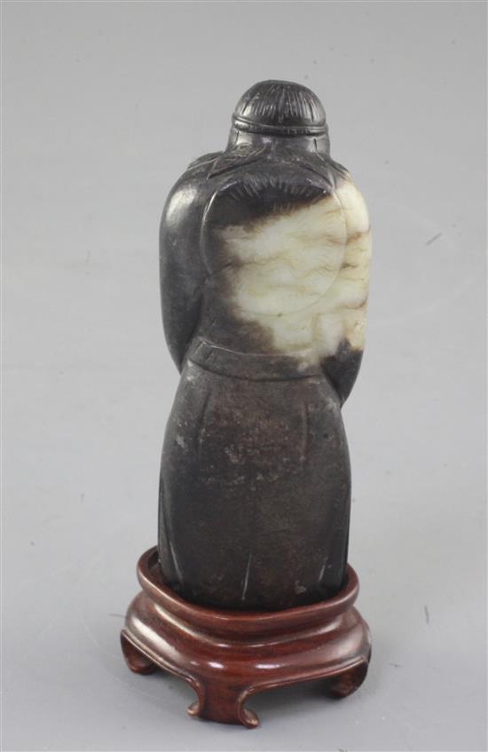 A Chinese white and black jade figure of a sage, possibly Han dynasty, height 9.1cm, wood stand